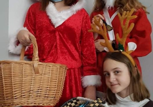 Dzieci w strojach Mikołaja i koszykiem