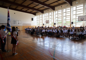 poczet sztandarowy szkoły obok społeczność szkolna