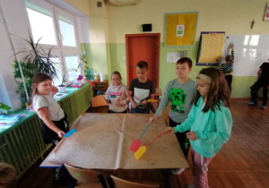 dzieci z łapkami na muchy w rękach pokazujące cyfry