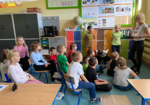 Dzieci siedzące na krzesłach i patrzące na znaki narodowe Niemiec