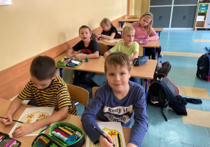 Dzieci w ławkach malujące godło Niemiec