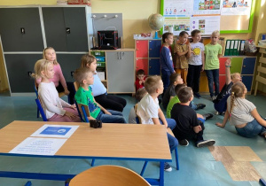 Dzieci siedzące na krzesłach i dywanie