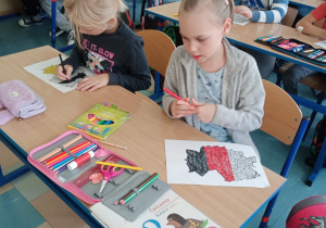 Dzieci w ławkach malujące flagę Niemiec