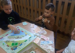 Chłopcy grają w grę planszową Monopoly