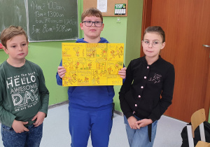 Chłopcy trzymający rysunek narysowanego przez siebie komiksu