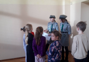 Dzieci stoją przy harcerzach