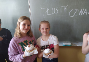 Dziewczynki z pączkami na tle napisu: Tłusty czwartek