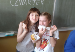Dziewczynki z pączkami na tle napisu: Tłusty czwartek