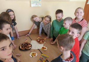 Dzieci wokół talerzyków z jedzeniem