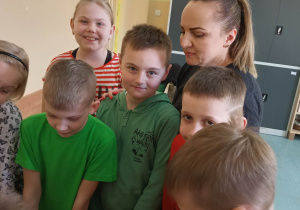 Dzieci z panią stoją przy stoliku