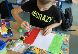 Chłopcy malują paski czerwony i zielony na fladze