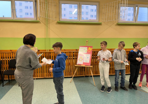 Pani wręcza dyplom chłopcu