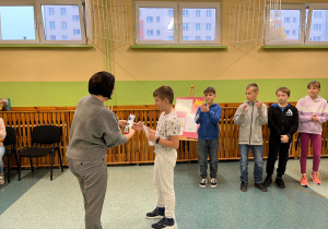 Pani wręcza dyplom chłopcu