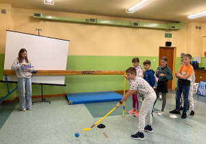 dzieci grają kijem do hokeja