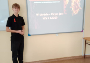 Chłopiec stoi przy tablicy