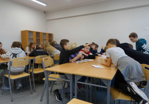 Dzieci w ławkach pracują z mulitontrolerami