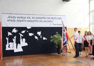 dekoracja i uczniowie trzymający poczet sztandardowy