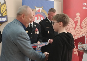 Mężczyzna wręcza nagrodę chłopcu