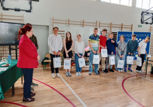 Grupa dzieci z torebkami prezentowymi pozuje do wspólnego zdjęcia