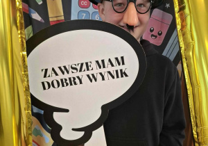 Dziecko w czarnym kapeluszu pozuje do zdjęcia w ramce