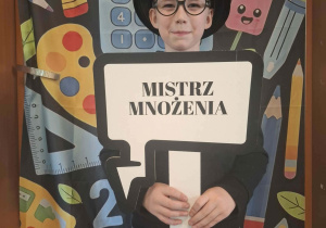 Dziecko w czarnym kapeluszu pozuje do zdjęcia w ramce