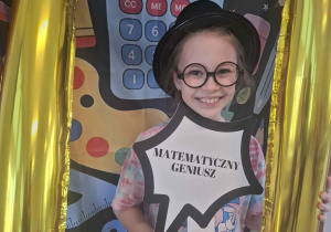 Dziecko w czarnym kapeluszu pozuje do zdjęcia w ramce