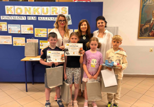 Trzy kobiety z uśmiechniętymi dziećmi, które trzymają prezenty