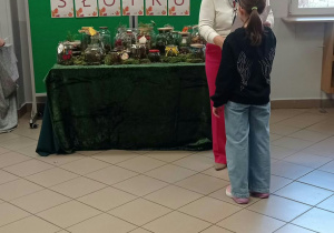 Kobieta wręcza dyplom dziecku.