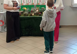 Kobieta wręcza dyplom dziecku.