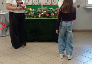 Kobieta wręcza dyplom dziecku.
