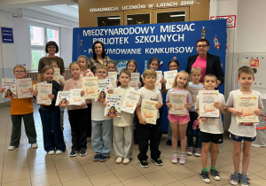 Kobiety z dziećmi trzymającymi dyplomy i nagrody