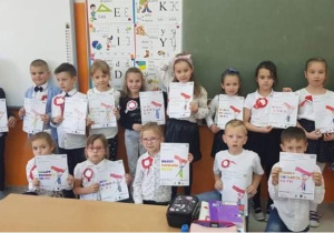 Dzieci klasy 1b otrzymały obrazki godła i flagi do pokolorowania