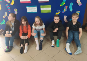 Dzieci w kolorowych skarpetkach na tle niebieskiej wystawy