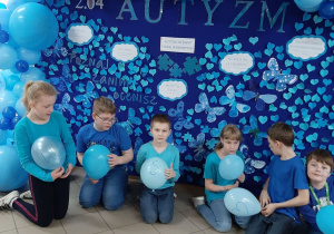 „niebieska” gazetka w holu głównym szkoły i dzieci trzymające niebieskie baloniki