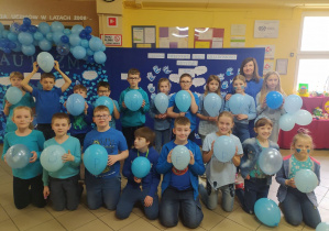 dzieci trzymające niebieskie baloniki „niebieskiej” gazetki
