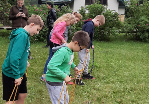 Dzieci maszerujące na deskach ze sznurkami