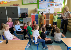 Dzieci siedzące na krzesłach i patrzące na znaki narodowe Niemiec