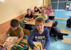 Dzieci w ławkach malujące godło Niemiec