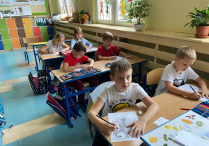 Dzieci w ławkach malujące godło Niemiec