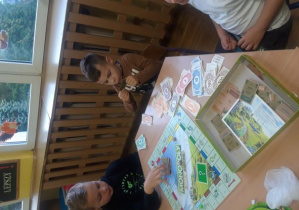 Chłopcy grają w grę planszową Monopoly