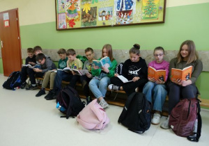 Dzieci siedzące na podłodze i czytające książki