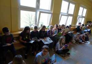 Dzieci siedzące na ławce i czytające książki