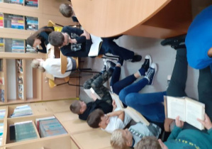 Dzieci siedzące w bibliotece i czytające książki