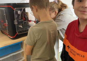 Chłopiec oglądający pracę drukarki 3D