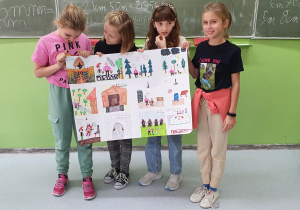 Dziewczynki trzymające rysunek narysowanego przez siebie komiksu