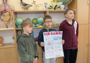 Chłopcy trzymający rysunek narysowanego przez siebie komiksu