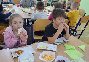 Dzieci jedzące kanapki z warzywami