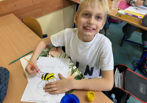 Chłopiec malujący obrazek pszczółki