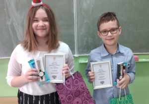 Chłopiec z dziewczynką trzymają dyplomy
