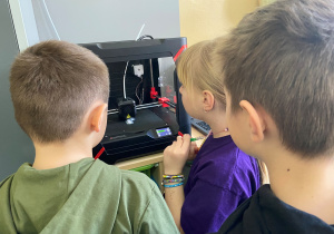 Dzieci obserwują pracę drukarki 3D
